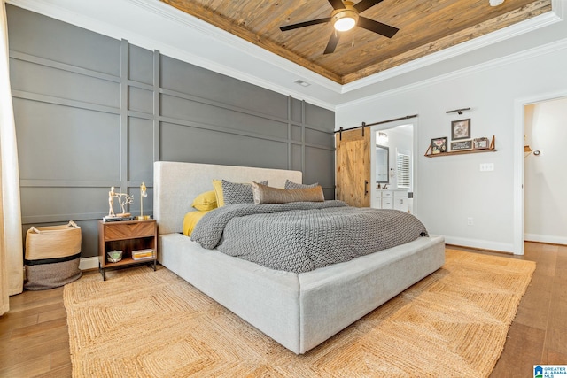 bedroom with ornamental molding, wood ceiling, light hardwood / wood-style floors, a raised ceiling, and a barn door