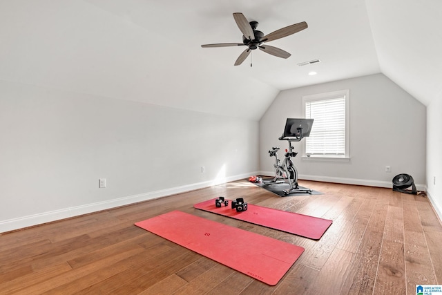 exercise room with ceiling fan, wood-type flooring, and vaulted ceiling