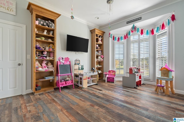 playroom with crown molding and dark wood-type flooring