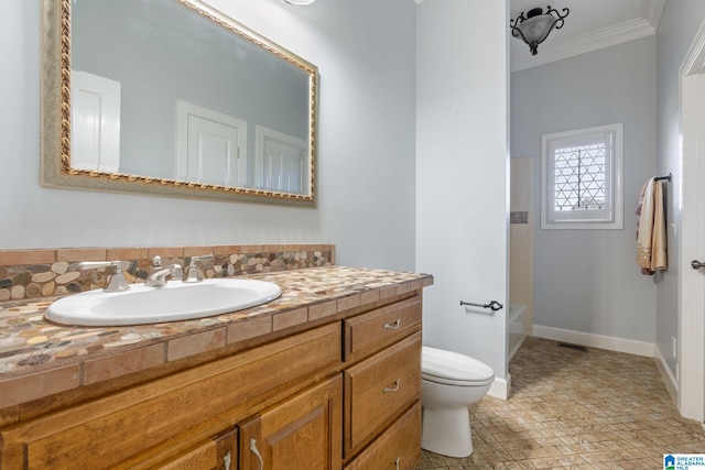 bathroom with ornamental molding, toilet, and vanity