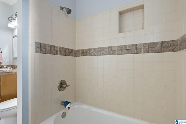 full bathroom with vanity, tiled shower / bath combo, and toilet