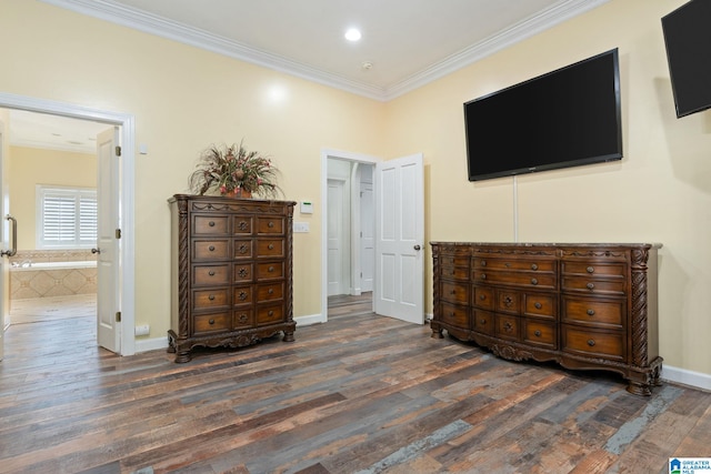 bedroom with ornamental molding, dark hardwood / wood-style flooring, and connected bathroom