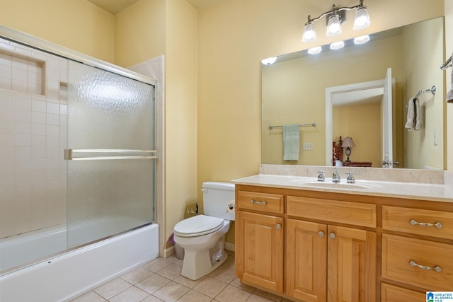 full bathroom featuring shower / bath combination with glass door, vanity, toilet, and tile patterned flooring