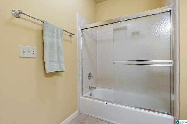 bathroom featuring tile patterned flooring and combined bath / shower with glass door