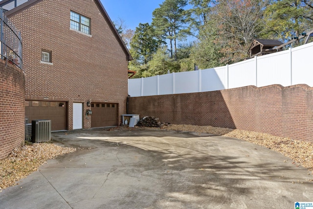 view of home's exterior with a garage and central AC