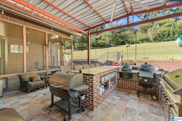 view of patio / terrace with a bar, grilling area, and exterior kitchen