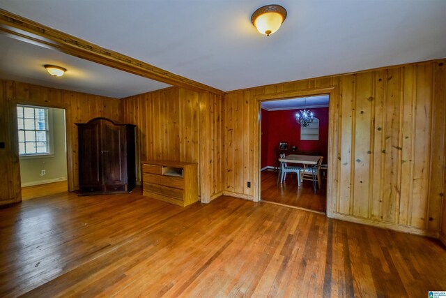 unfurnished living room with hardwood / wood-style flooring and a chandelier