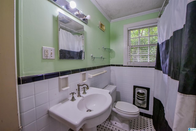 bathroom with sink, tile walls, tile patterned flooring, ornamental molding, and a textured ceiling