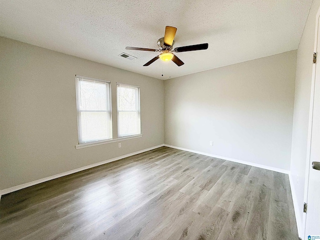 unfurnished room with ceiling fan, light hardwood / wood-style floors, and a textured ceiling