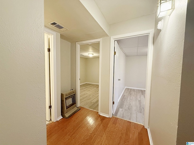 hallway featuring wood-type flooring and heating unit