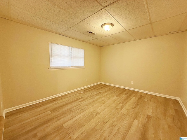 spare room featuring a paneled ceiling and wood-type flooring