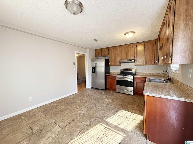 kitchen featuring sink, stainless steel appliances, and a textured ceiling