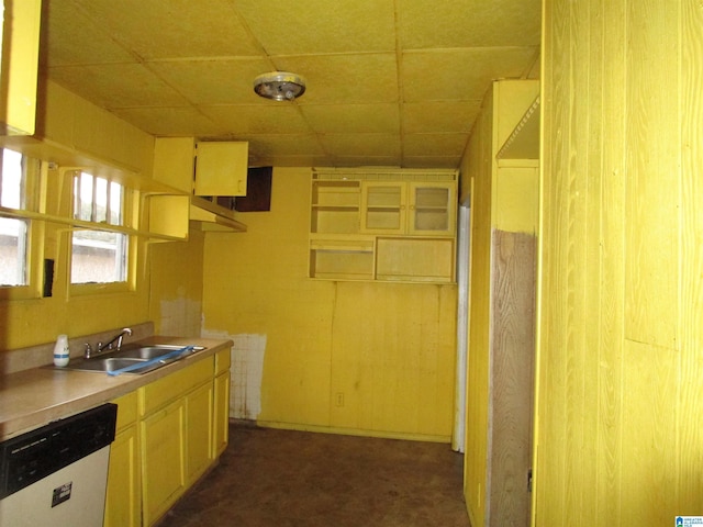 kitchen with a drop ceiling, sink, dishwasher, and dark colored carpet