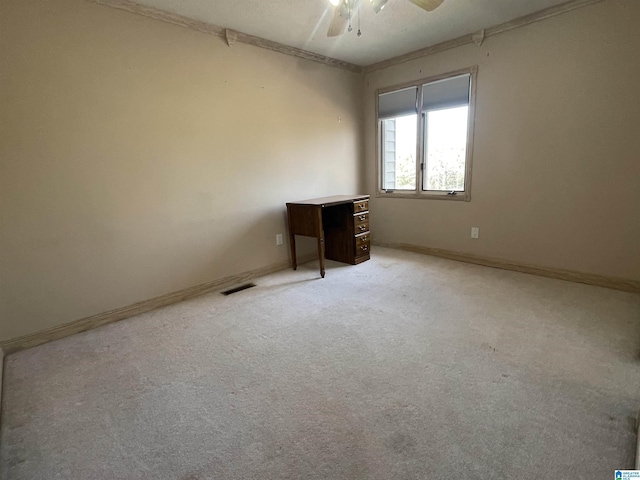 carpeted empty room featuring ornamental molding and ceiling fan