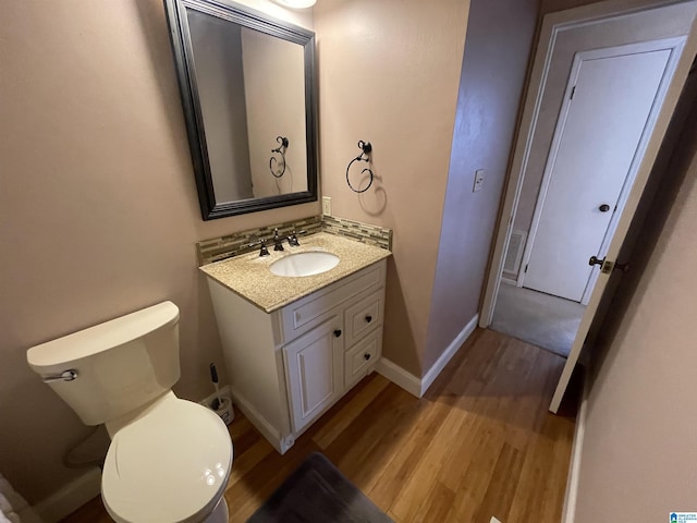 bathroom featuring vanity, hardwood / wood-style flooring, and toilet