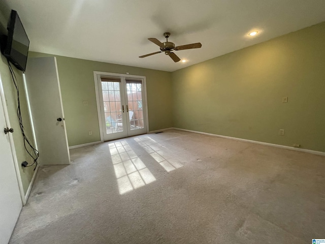 carpeted empty room featuring ceiling fan and french doors