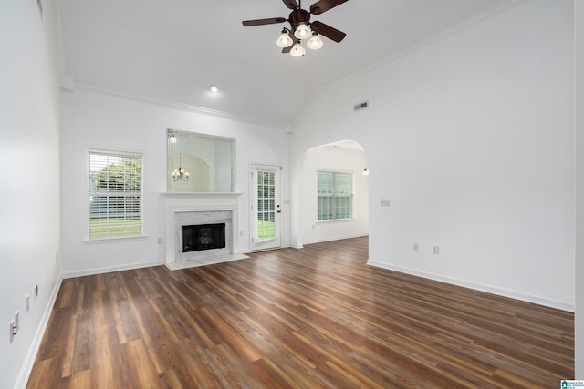 unfurnished living room featuring ceiling fan, high vaulted ceiling, a high end fireplace, ornamental molding, and dark hardwood / wood-style flooring