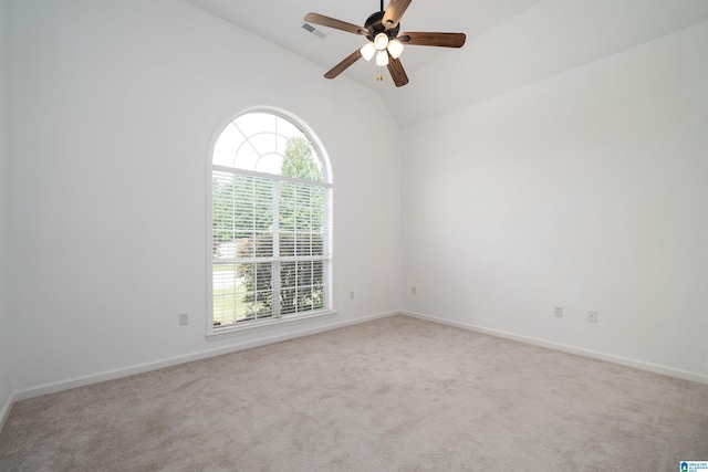 spare room featuring vaulted ceiling, light colored carpet, and ceiling fan