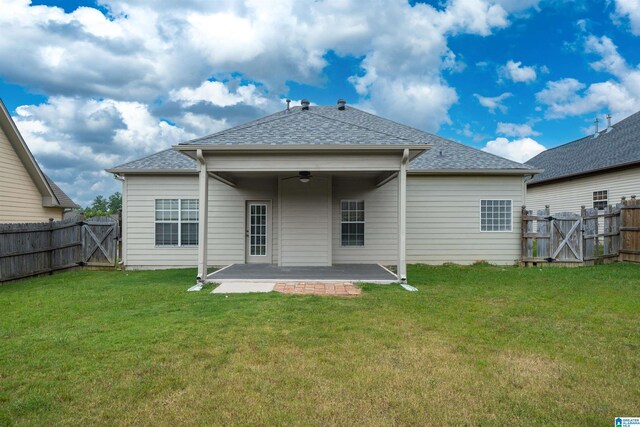 back of property with ceiling fan, a patio area, and a lawn