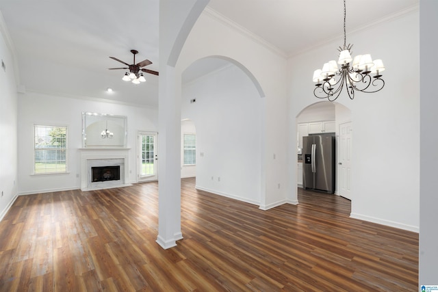 unfurnished living room featuring crown molding, ceiling fan, a high ceiling, a high end fireplace, and dark hardwood / wood-style flooring