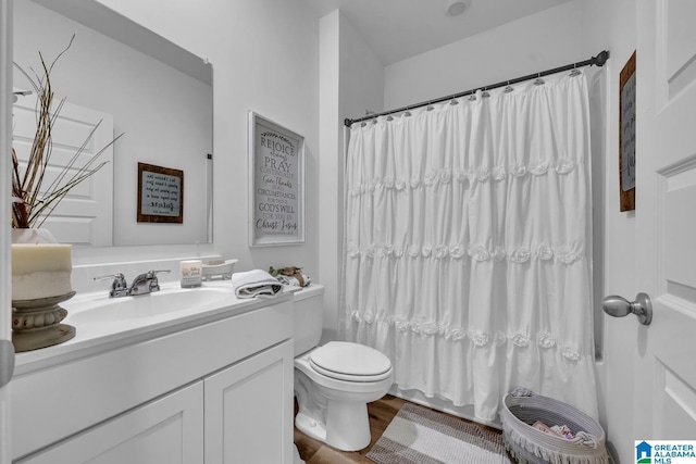 full bathroom featuring hardwood / wood-style flooring, vanity, shower / tub combo, and toilet