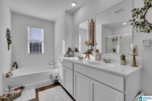 bathroom featuring hardwood / wood-style flooring, vanity, and separate shower and tub