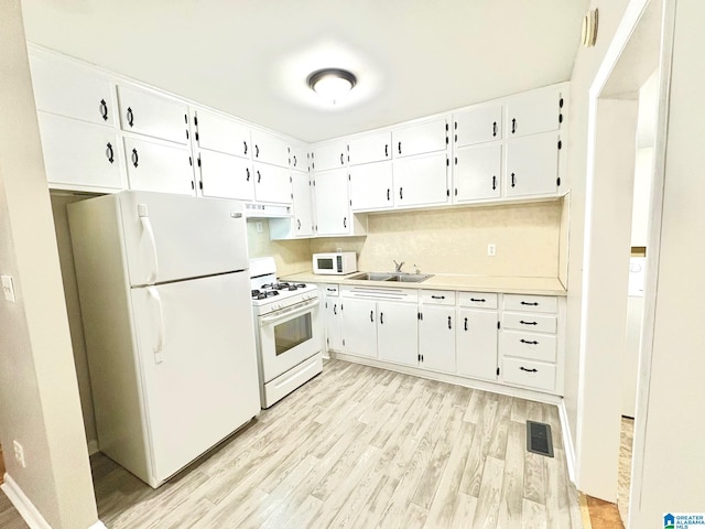 kitchen with visible vents, light countertops, white cabinets, and white appliances