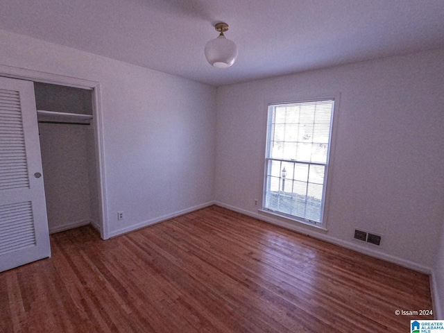 unfurnished bedroom featuring hardwood / wood-style floors and a closet