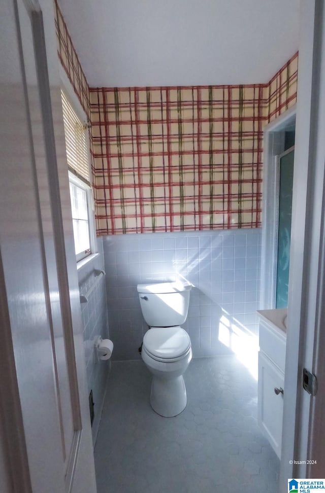 bathroom featuring tile walls, vanity, and toilet