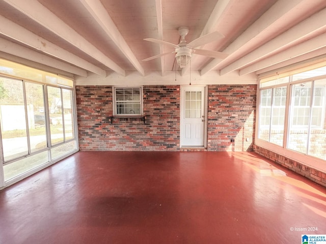 unfurnished sunroom featuring beamed ceiling and ceiling fan