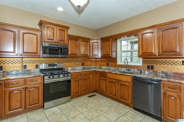 kitchen featuring tasteful backsplash, sink, stainless steel appliances, and dark stone counters