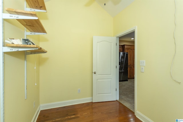 unfurnished room with dark wood-type flooring, ceiling fan, and vaulted ceiling