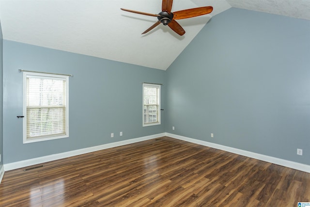 empty room featuring vaulted ceiling, dark hardwood / wood-style floors, and ceiling fan