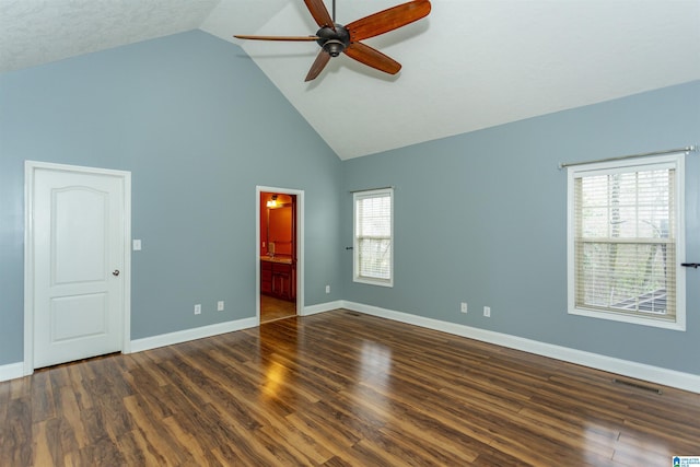 spare room featuring ceiling fan, high vaulted ceiling, dark hardwood / wood-style floors, and a healthy amount of sunlight