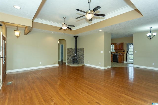 unfurnished living room featuring hardwood / wood-style flooring, crown molding, ceiling fan with notable chandelier, and a textured ceiling