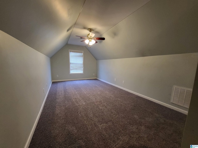 bonus room with lofted ceiling, dark carpet, and ceiling fan