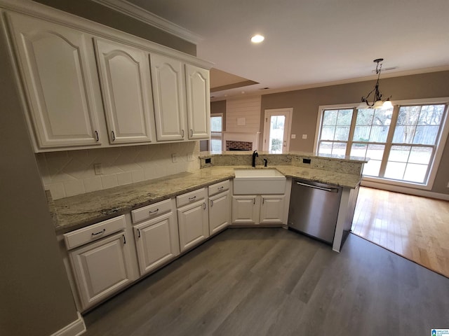 kitchen with pendant lighting, sink, tasteful backsplash, stainless steel dishwasher, and kitchen peninsula