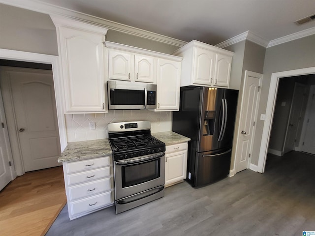 kitchen with hardwood / wood-style flooring, light stone countertops, appliances with stainless steel finishes, and white cabinets