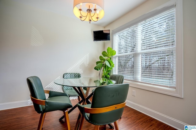 dining space with dark hardwood / wood-style floors and a chandelier