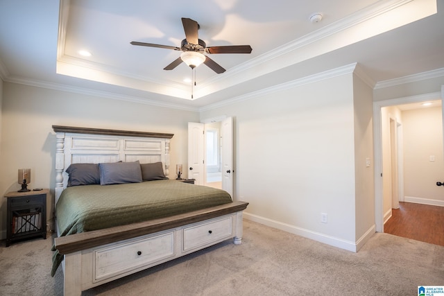 carpeted bedroom with a raised ceiling, crown molding, and ceiling fan