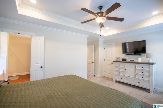 unfurnished bedroom featuring ornamental molding, a tray ceiling, and light carpet