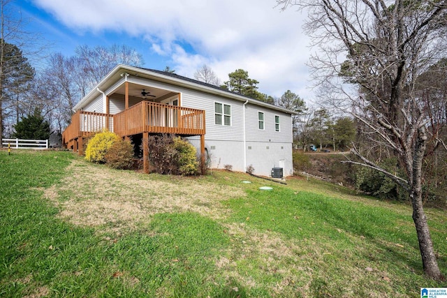 rear view of property featuring a wooden deck, a yard, and ceiling fan