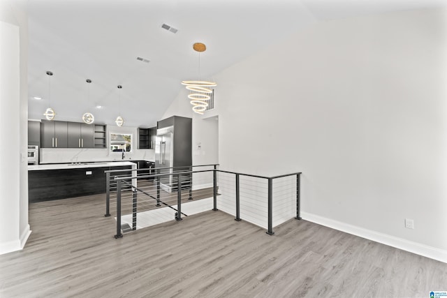 interior space featuring lofted ceiling and light hardwood / wood-style flooring