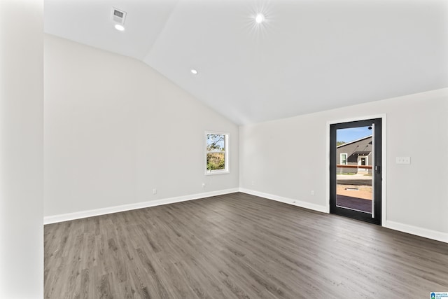 spare room featuring lofted ceiling and dark hardwood / wood-style flooring