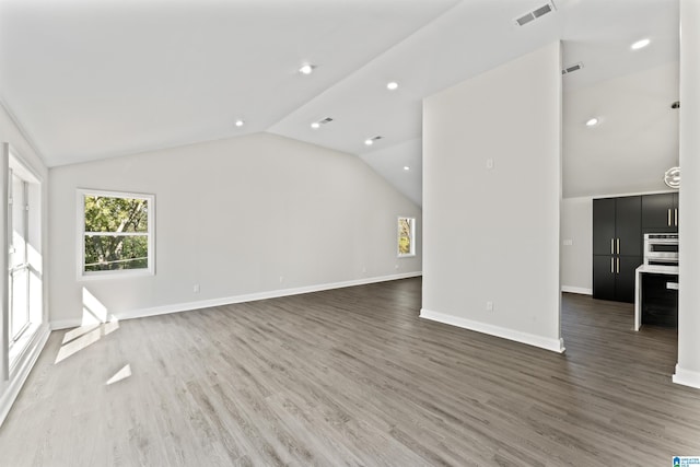 unfurnished living room featuring lofted ceiling and dark hardwood / wood-style floors