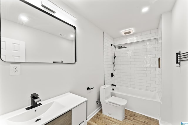 full bathroom with tiled shower / bath combo, wood-type flooring, vanity, and toilet