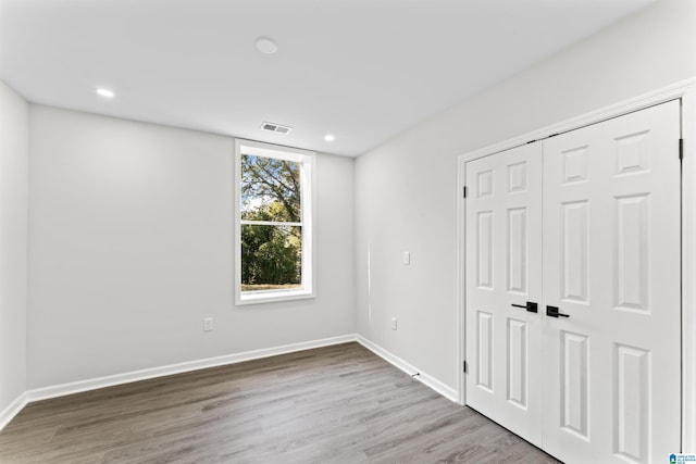 unfurnished bedroom with hardwood / wood-style flooring and a closet