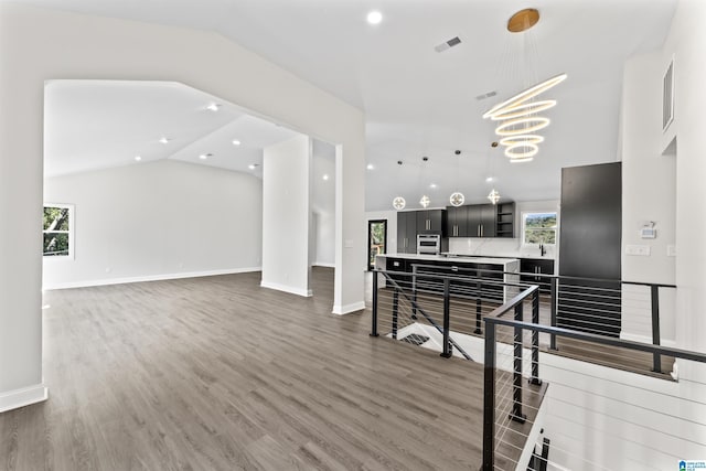 living room with dark wood-type flooring, vaulted ceiling, and a chandelier