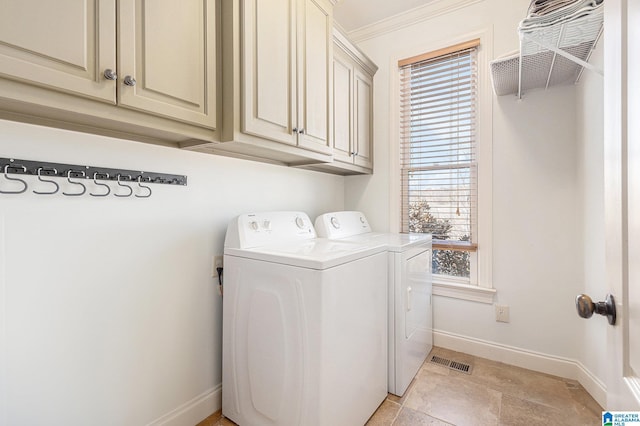 laundry area with crown molding, cabinets, and washer and clothes dryer