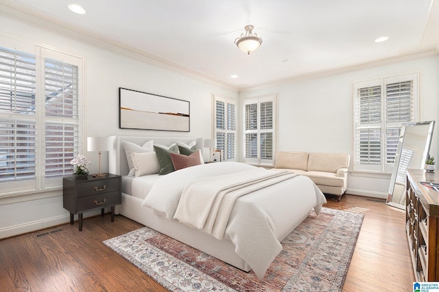 bedroom featuring crown molding, wood-type flooring, and multiple windows